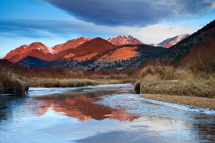 The Mummy Range reflected in the frozen water of Fall River, Rocky Mountain National Park