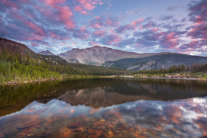 Pink clouds drift over a calm Sandbeach Lake deep in the heart of Rocky Mountain National Park. Mount Meeker, Longs Peak and Pagoda Peak can be seen reflecting in the calm waters of Sandbeach Lake. John Wesley Powell is said to have camped near this location nearly 145 years ago prior to making the first successful ascent to the summit of Longs Peak. Technical Details: Canon EOS 5D Mark III, 17mm TS-E F4 L 