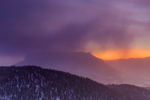 Wind blown snow flies across the horizon and over Deer Mountain as the orange pre dawn glow of sunrise begins to light the sky over Rocky Mountain National Park. Technical Details: Canon EOS 5D Mark III, 24-70mm F4 IS