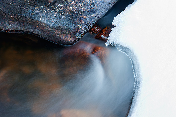 Photographing Rocky Mountain National Park during the transitional season from winter to spring can be a frustrating experience. More often than not it will feel more like winter than spring in Rocky. Partially thawing streams make for a good subject even on cloudy and drab days. Here I was able to find a small area of Glacier Creek that had thawed enough to photograph water moving under and around the snowpack. Technical Details: Canon EOS 1Ds III, 24-70mm F4 IS L