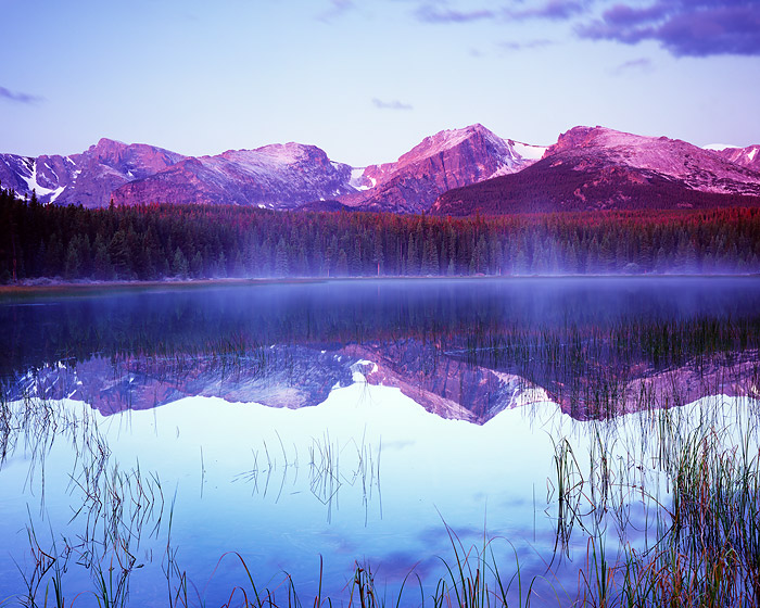 A brilliant sunrise illumintes Hallet Peak as it reflects in the placid waters of Bierstadt Lake. Rocky Mountain National Park...