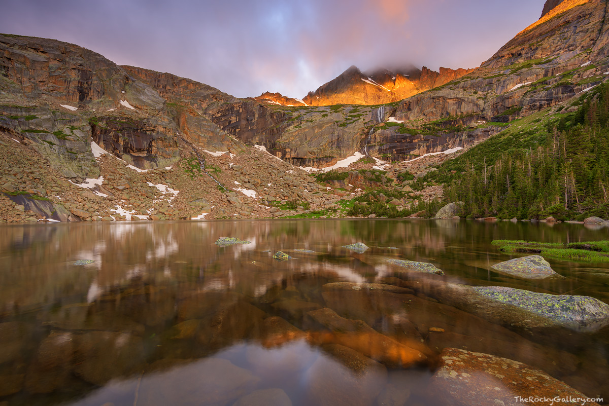 Storm clouds roil over the summit of McHenrys Peak at sunrise. This morning some sun managed to filter through the clouds and...