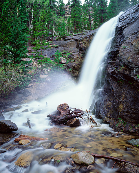 Cow Creek tumbles 20 feet over the granite and rock that forms Bridal Veil Falls in Rocky Mountain National Park. Rain and mist...