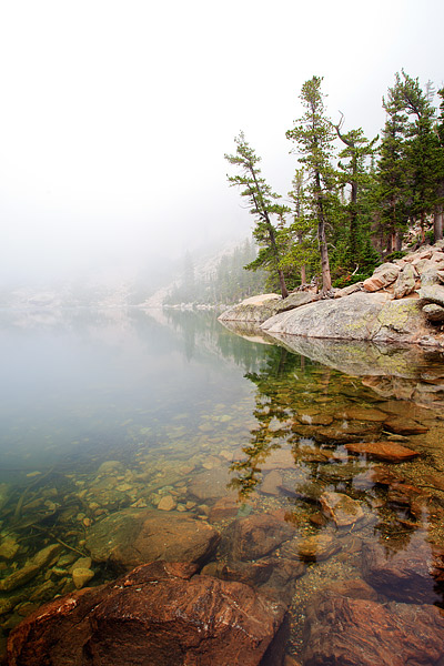 Fog shrouds Flattop Mountain and Emerald Lake in Rocky Mountain National Park. Flattop Mountain is obscured by the Fog but the...