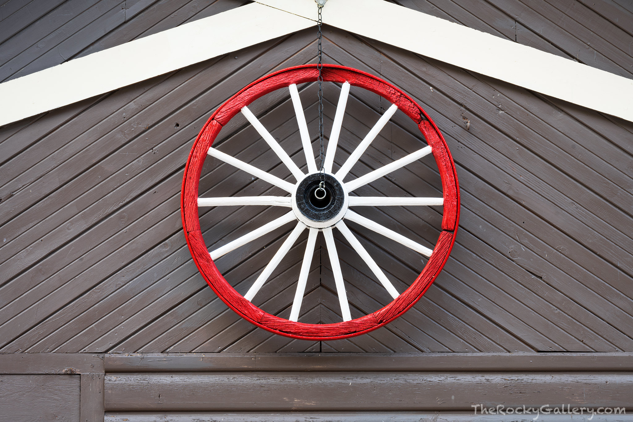 A clapboard wagon wheel hangs on the side of the Gateway Grocery store just outside the Fall River Entry to Rocky Mountain National...