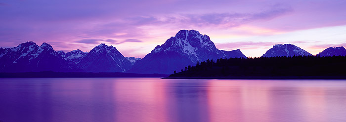 After a violent thunderstorm, pastel light bathes Mt. Moran and the Grand Tetons from the shores of Jackson Lake