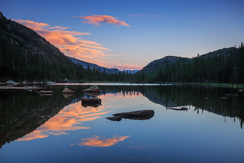 It's a quiet and still morning on the east side of Rocky Mountain National Park. A few clouds glide over Rocky and are reflected...