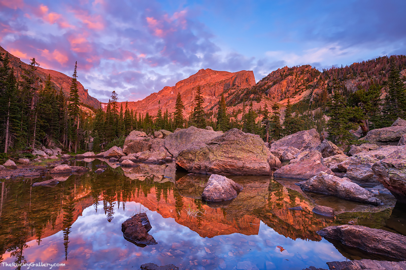 Hallett Peak glows red as the first light of the day lights the peak from Lake Haiyaha. Lake Haiyaha which translates to&nbsp...