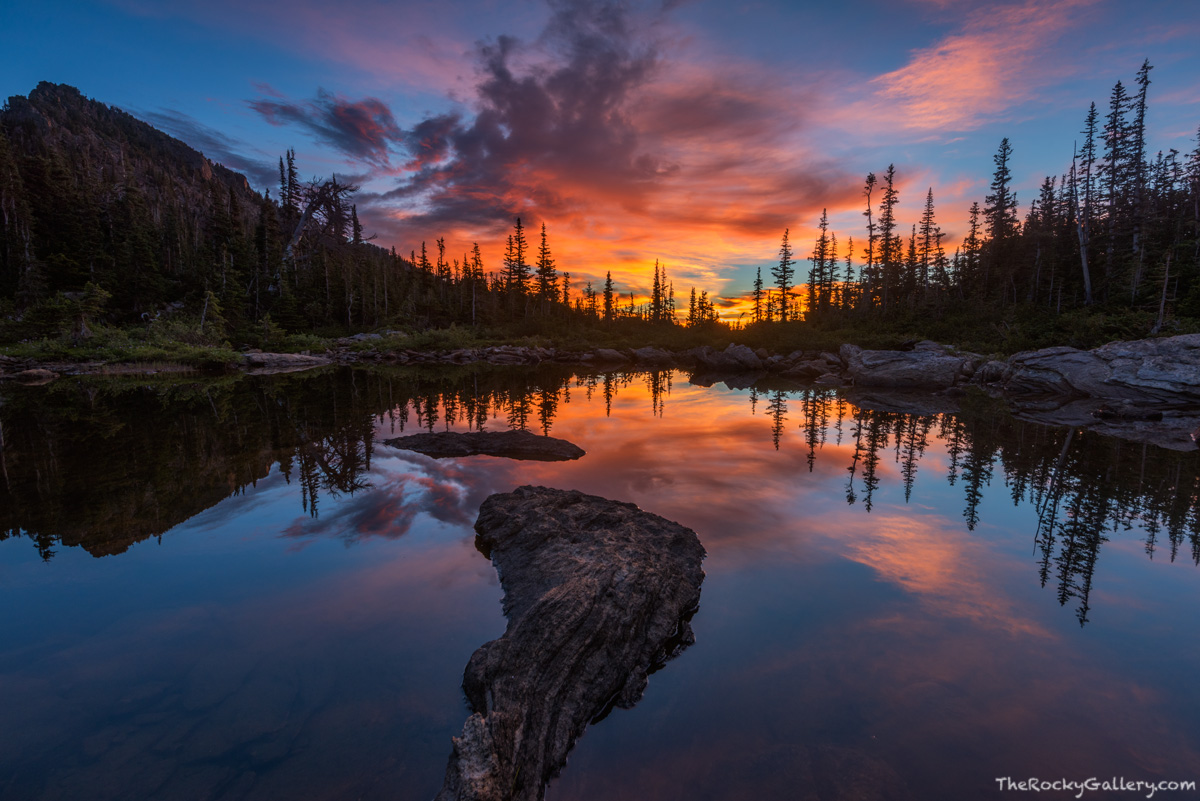 Clouds to the south of Marigold Ponds pickup the early colors of sunrise on a peaceful and placid morning in Rocky Mountain National...