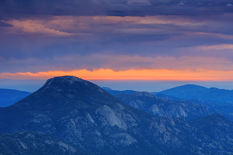 Rain showers move over the Estes Valley subduing the sunrise over Rocky Mountain National Park. McGregor Mountain and Lumpy Ridge...