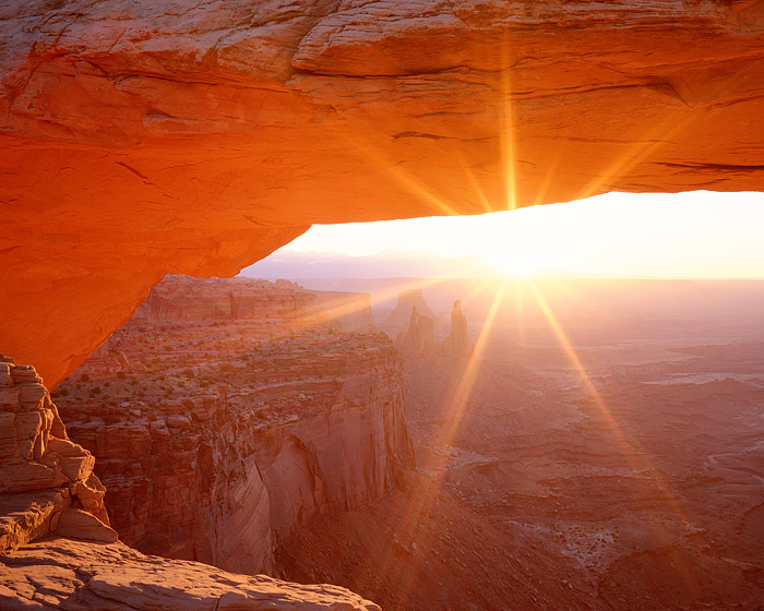 Mesa Arch in Canyonlands National Park welcomes the sunrise through it's grand sandstone arch. Looking east towards Utah's La...