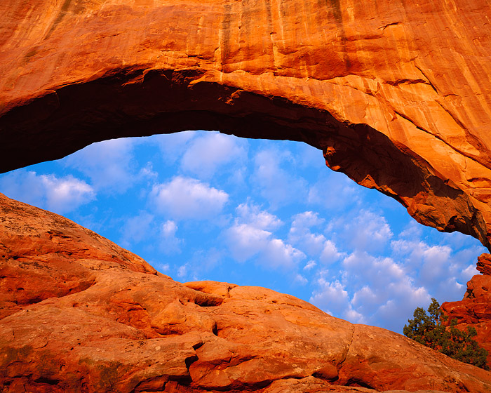 Clouds skirt above North Window Arch on a warm but beautiful morning in Arches National Park. Arches National Park is located...