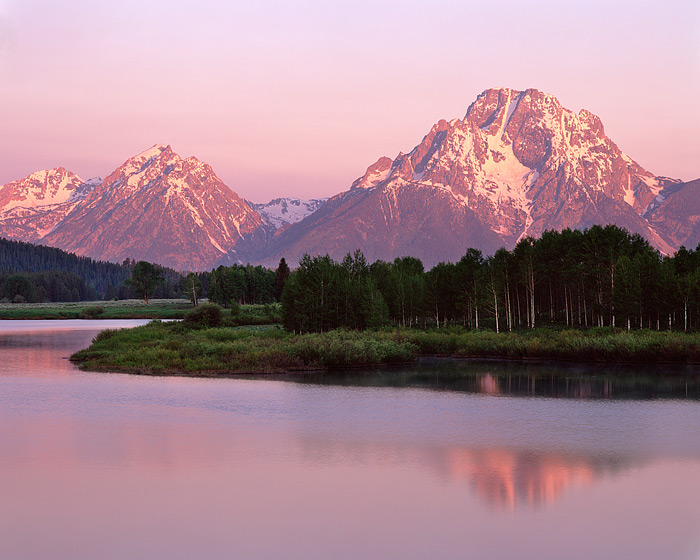 The magenta hue of sunrise light up Mt. Moran at Oxbow Bend. Oxbow Bend on the Wyoming's Snake River is one of Grand Teton National...