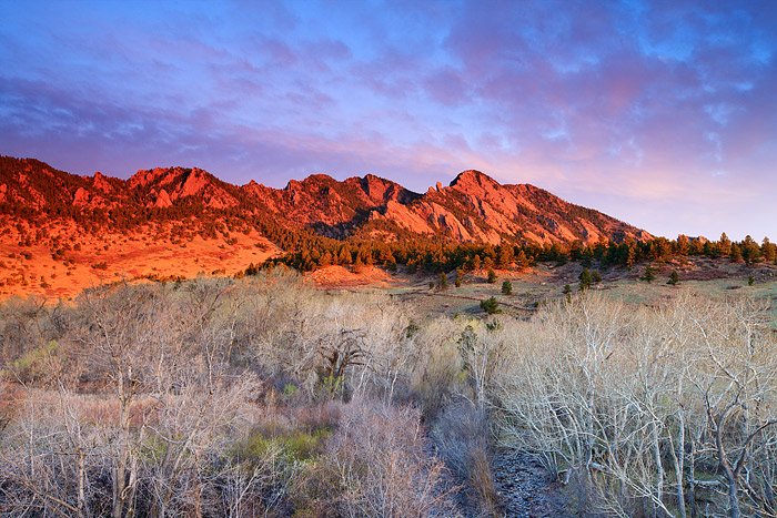 South Boulder Peak turns a fiery red as the first rays of light coat the Flatirons just outside of Boulder, Colorado. Spring...