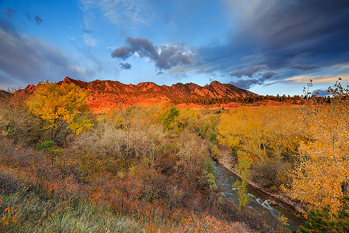 Patches of sunlight illuminate the Flatirons as a dramatic sunrise unfolds over Eldorado Springs and Boulder. South Boulder creek...