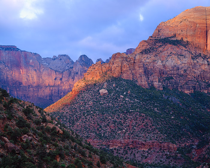 The sunrise breifly shines through the thick cloud cover over Zion National Park. The lighting, although brief helps highlight...