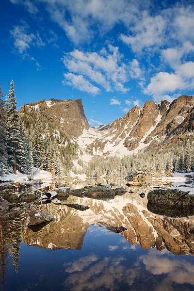 Clouds hover over Hallet Peak and Flattop Mountain after a fresh spring snow has fallen on Dream Lake. A perfect reflection has...