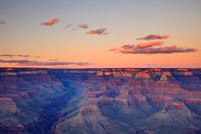 The last few clouds of the afternoon glow red and orange as they hover over Bright Angel Canyon. This view of the Grand Canyon...